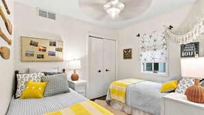 A bedroom with two beds, a wall clock, a window with star decorations, and a hammock. - Waterfront Condo | King Bed | Walk to Douglas (Douglas)