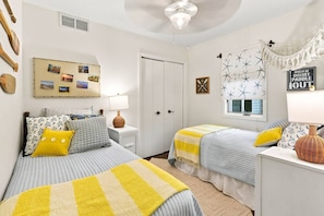 A bedroom with two beds, a wall clock, a window with star decorations, and a hammock. - Waterfront Condo | King Bed | Walk to Douglas (Douglas)
