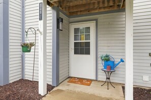 A house entrance with a door, a mailbox, a small table with a watering can, and a potted plant. - Waterfront Condo | King Bed | Walk to Douglas (Douglas)