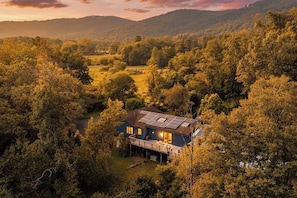 Una casa envoltada de bosc dens amb una vista clara del paisatge circumdant.