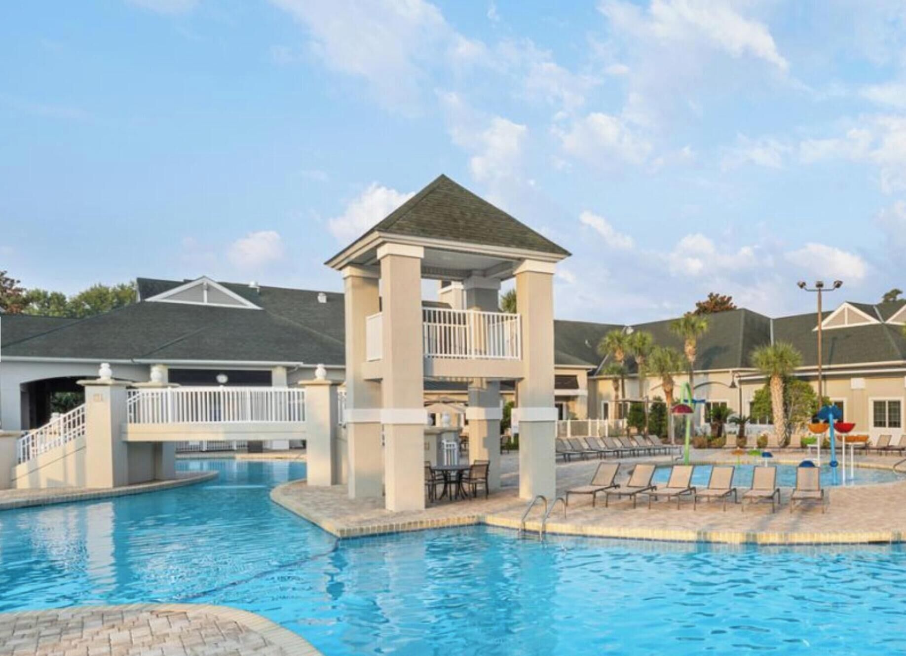 A swimming pool with lounge chairs and a covered pavilion.