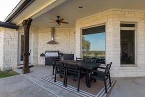 An outdoor patio with a grill, dining table, and chairs. - The Shiloh Ranch in Thrall (Thrall)