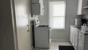 A kitchen with a refrigerator, stove, microwave, and cabinets. - Adorable 2-bedroom apartment with AC in cool Detroit (Detroit)
