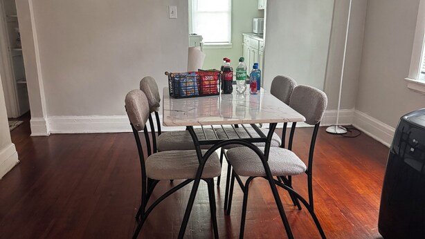 A dining area with a wooden table and chairs, a basket of snacks, and a floor lamp. - Adorable 2-bedroom apartment with AC in cool Detroit (Detroit)