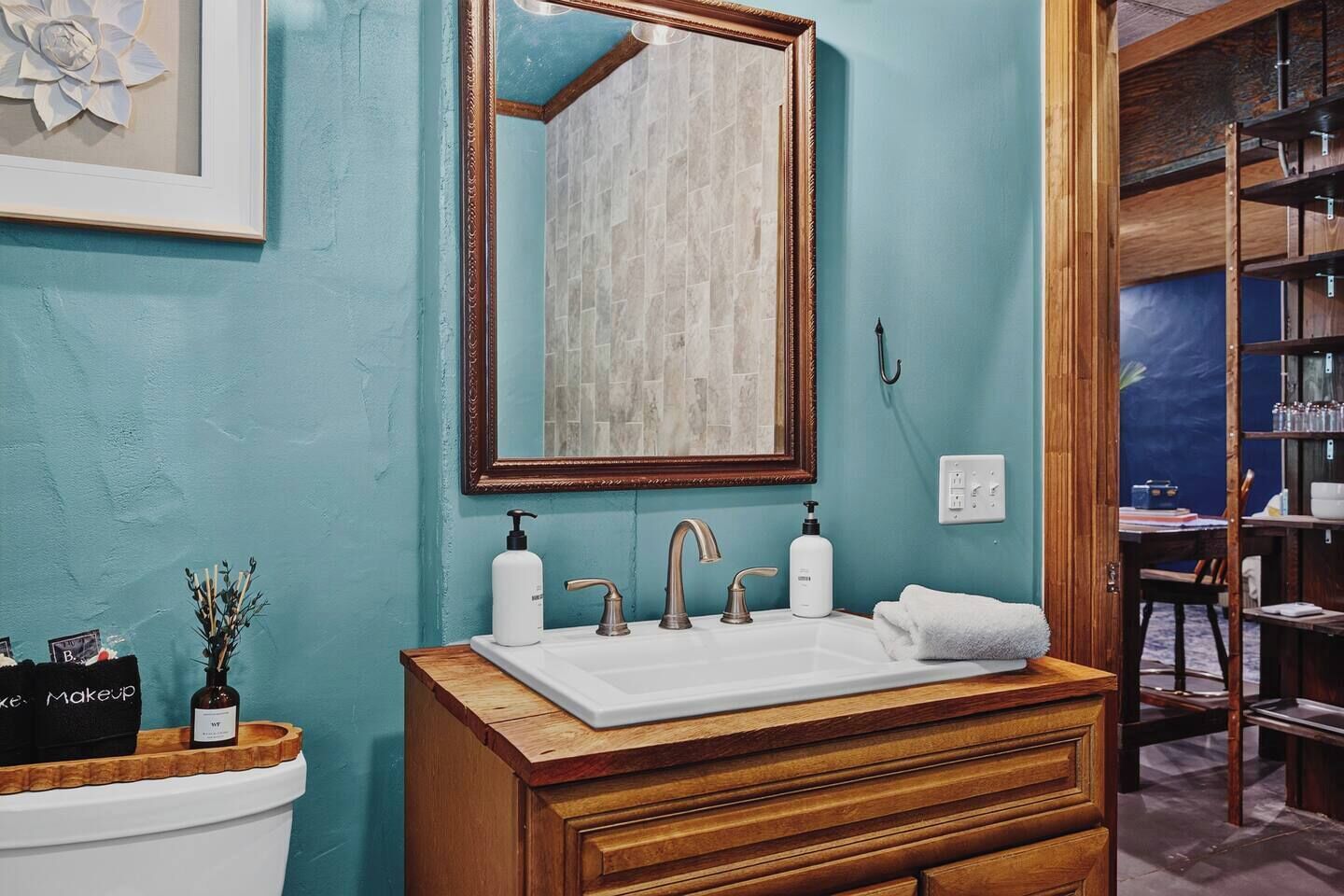 Une salle de bain avec un meuble-lavabo en bois, un lavabo blanc et un miroir.