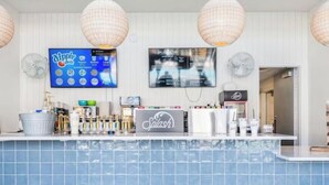 A bar area with a blue tiled counter, a television screen displaying a menu, and a sign for 'Splash'. -  DesertColor St. George Spacious 4-bedroom house pool & hot tub front door steps (St. George)
