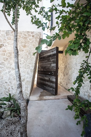 A rustic wooden gate leading to a stone-walled building. - VillaLaGrieta: Luxury Eco-Villa, Lagoon &Cenotes access, Ocean Views in Akumal (AKUMAL)