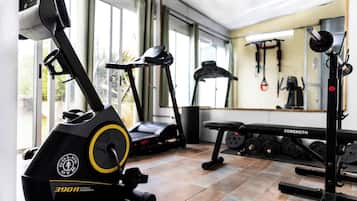 A gym with a stationary bike, treadmill, and weight bench.