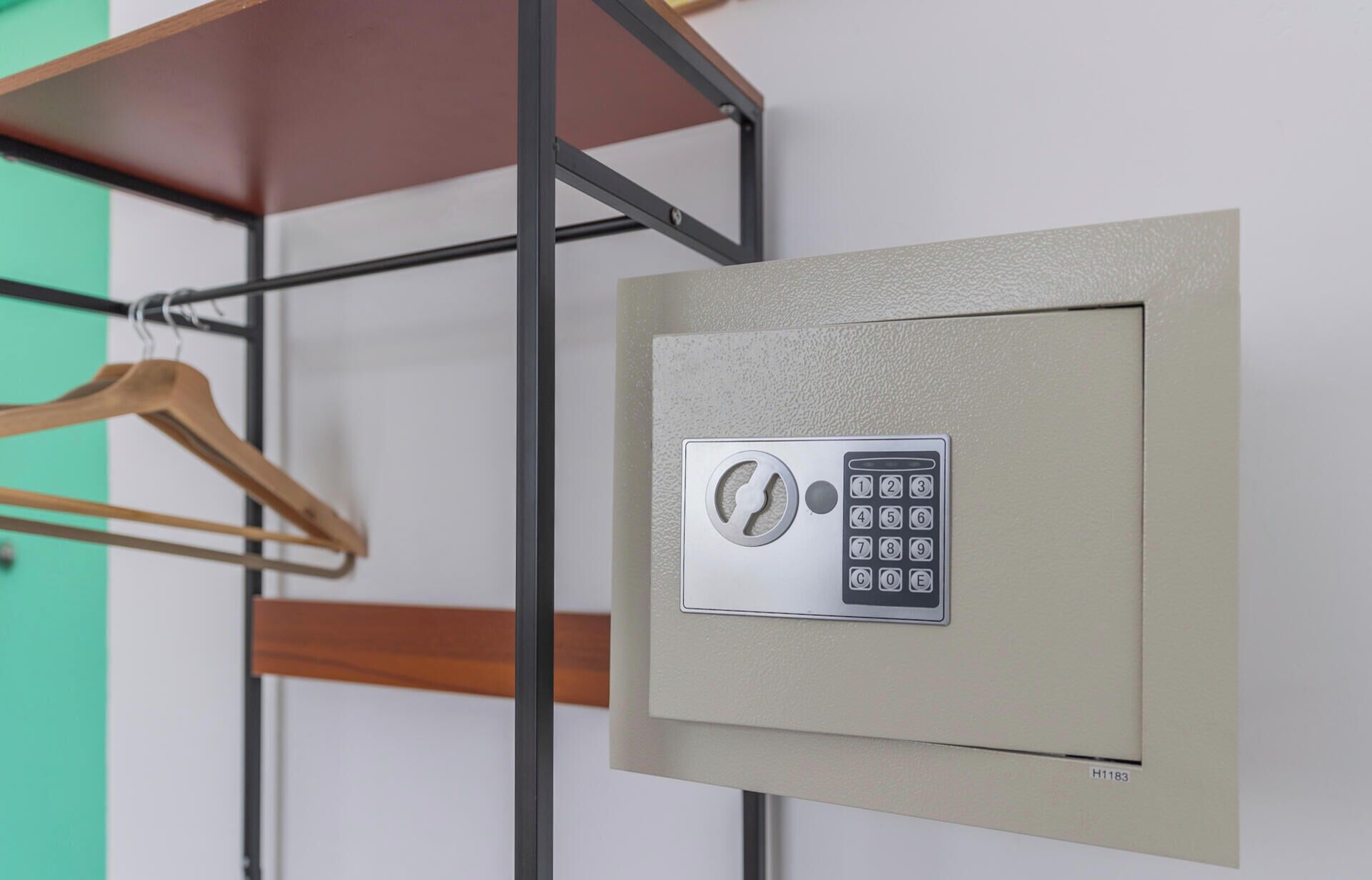 A secure door with a keypad lock, a wooden hanger, and a metal frame.
