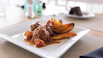 A plate with meatballs and roasted potatoes.