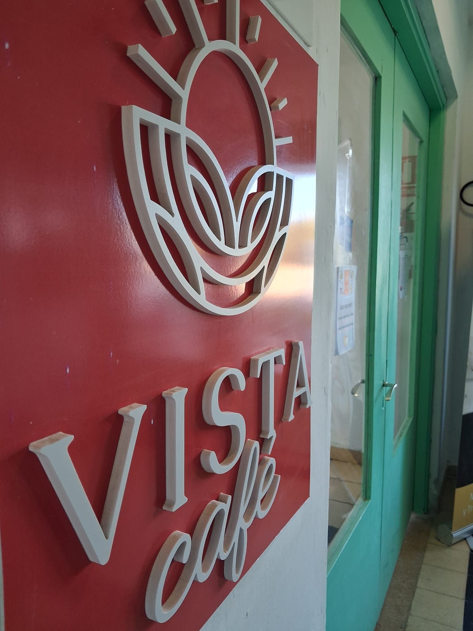 A sign with the text 'VISTA café' and a stylized sun graphic.