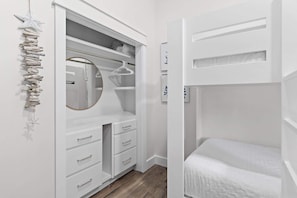 A bedroom with a bunk bed, a wardrobe with multiple drawers, and a mirror. - Seagrove Gardens - Community Pool & 4 Bikes! (Santa Rosa Beach)