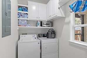 A compact laundry area with a washing machine, dryer, and a microwave. - Seagrove Gardens - Community Pool & 4 Bikes! (Santa Rosa Beach)