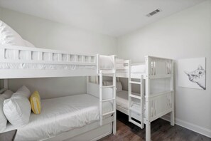 A bunk bed room with white bedding and a single yellow pillow. - Pet-Friendly 30A Cottage w/ Fenced Yard! (Santa Rosa Beach)