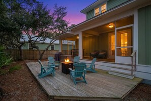 Une terrasse en bois avec des sièges d’extérieur et un foyer.
