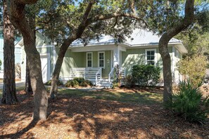 A two-story house with a front porch, surrounded by trees and a lawn. - Pet-Friendly 30A Cottage w/ Fenced Yard! (Santa Rosa Beach)