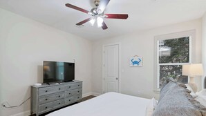 A bedroom with a bed, a TV on a dresser, a ceiling fan, and a window with blinds. - Pet-Friendly 30A Cottage w/ Fenced Yard! (Santa Rosa Beach)