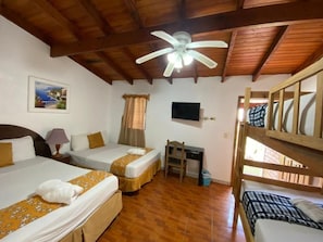 A room with two beds, a desk, a ceiling fan, and a television. - Hotel Villas del Valle (Valle de Angeles)