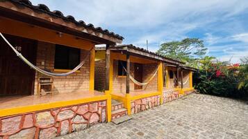 Um edifício com fachada de tijolos, detalhes em amarelo e telhado telhado.