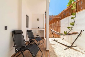 A patio with two black lounge chairs, a hammock, and a small sink area. - Private Jacuzzi | Pool | La Veleta (Tulum)