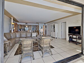 A living room with a sofa, two wicker chairs, a television, and a cabinet. - 2-bedroom Beach-front apartment in Punta Russa (Fort Myers)