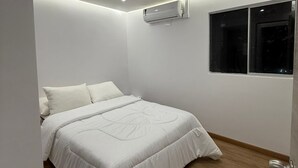 A bedroom with a bed, an air conditioning unit, a window, and a door. - 3 bedrooms | Private balcony, 5 min. from the beach (Cartagena de Indias)