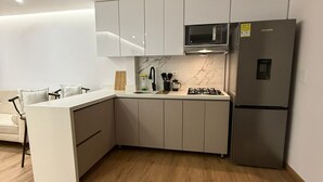 A modern kitchen with white cabinetry, a built-in microwave, and a stainless steel refrigerator. - 3 bedrooms | Private balcony, 5 min. from the beach (Cartagena de Indias)