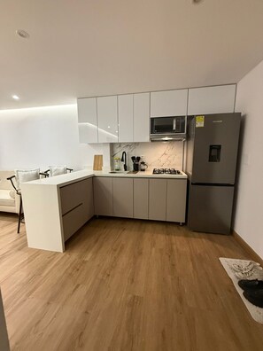 A modern kitchen with white cabinetry, a built-in microwave, and a stainless steel refrigerator. - 3 bedrooms | Private balcony, 5 min. from the beach (Cartagena de Indias)