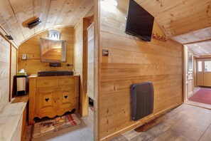 Un interior de madera con un armario, un espejo, un calentador y una puerta que da a otra habitación.