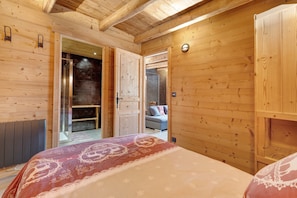 Un interior de madera con una cama, un baño y un área de descanso.