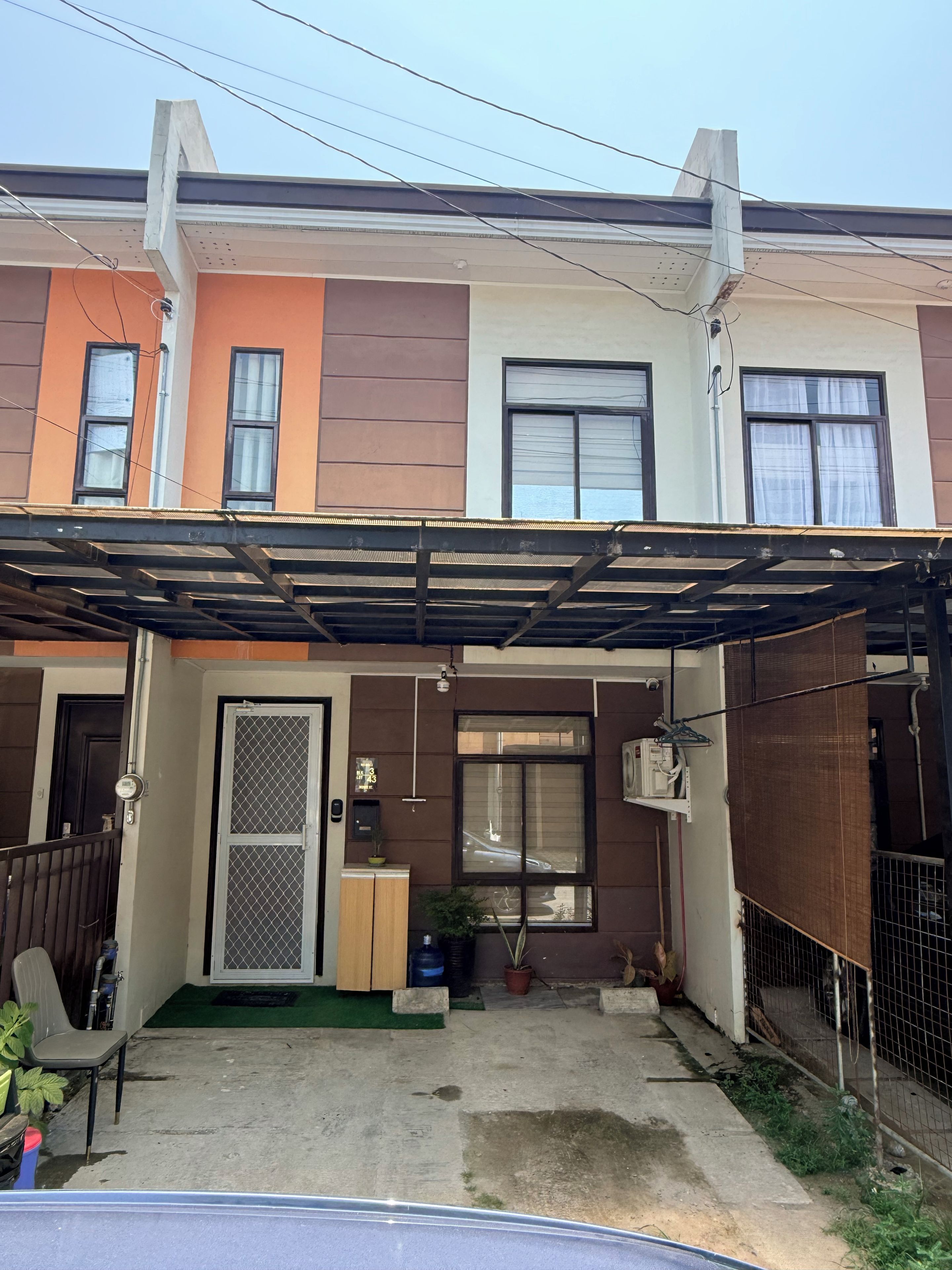 Un immeuble résidentiel doté d’un patio couvert, d’une entrée sécurisée et d’un petit jardin.