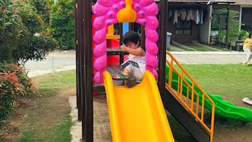 A playground with a slide and climbing structures.