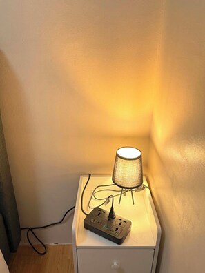 Ett sängbord med en lampa och en grenuttag.