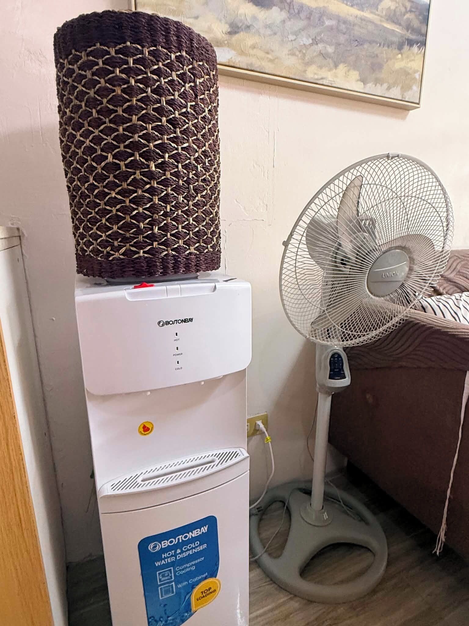 Dispensador de agua fría y caliente Boston Bay con sistema de enfriamiento por compresor, sobre un gabinete blanco.