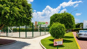 A gated parking area with a sign indicating a restricted area and a prohibition on dogs.