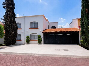 A two-story residential building with a tiled roof, a garage, and a paved driveway. - JC6 Executive Loft L1 in Pueblo Nuevo, Corregidora (El Pueblito)