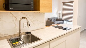 A modern kitchen with a built-in microwave, a sink with a faucet, and a countertop.
