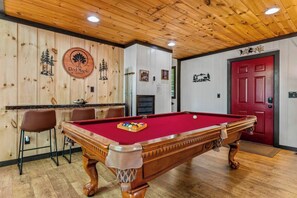 Ein Billardtisch mit roter Filzauflage, Holzschläger und einem weißen Spielball.