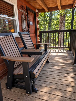 A wooden deck with two benches and a railing.
