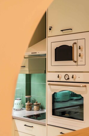Une cuisine équipée d’un four encastré, d’un four à micro-ondes et d’une plaque de cuisson. Il y a deux bocaux sur le comptoir.
