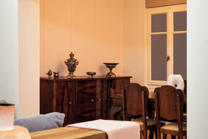 Un coin repas comprenant une table en bois, des chaises et un meuble contenant des objets décoratifs.