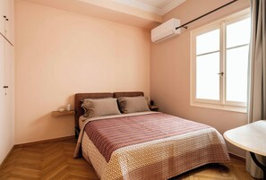 A bedroom with a bed, a window, and an air conditioning unit. - Ivelia Athens - Boutique Residence with Private Spa (Athina)