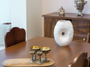 A wooden dining table with a white vase and four metal goblets on a wooden tray. - Ivelia Athens - Boutique Residence with Private Spa (Athina)