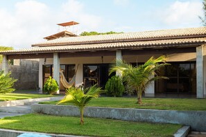 A house with a tiled roof, a covered porch, and a swimming pool.