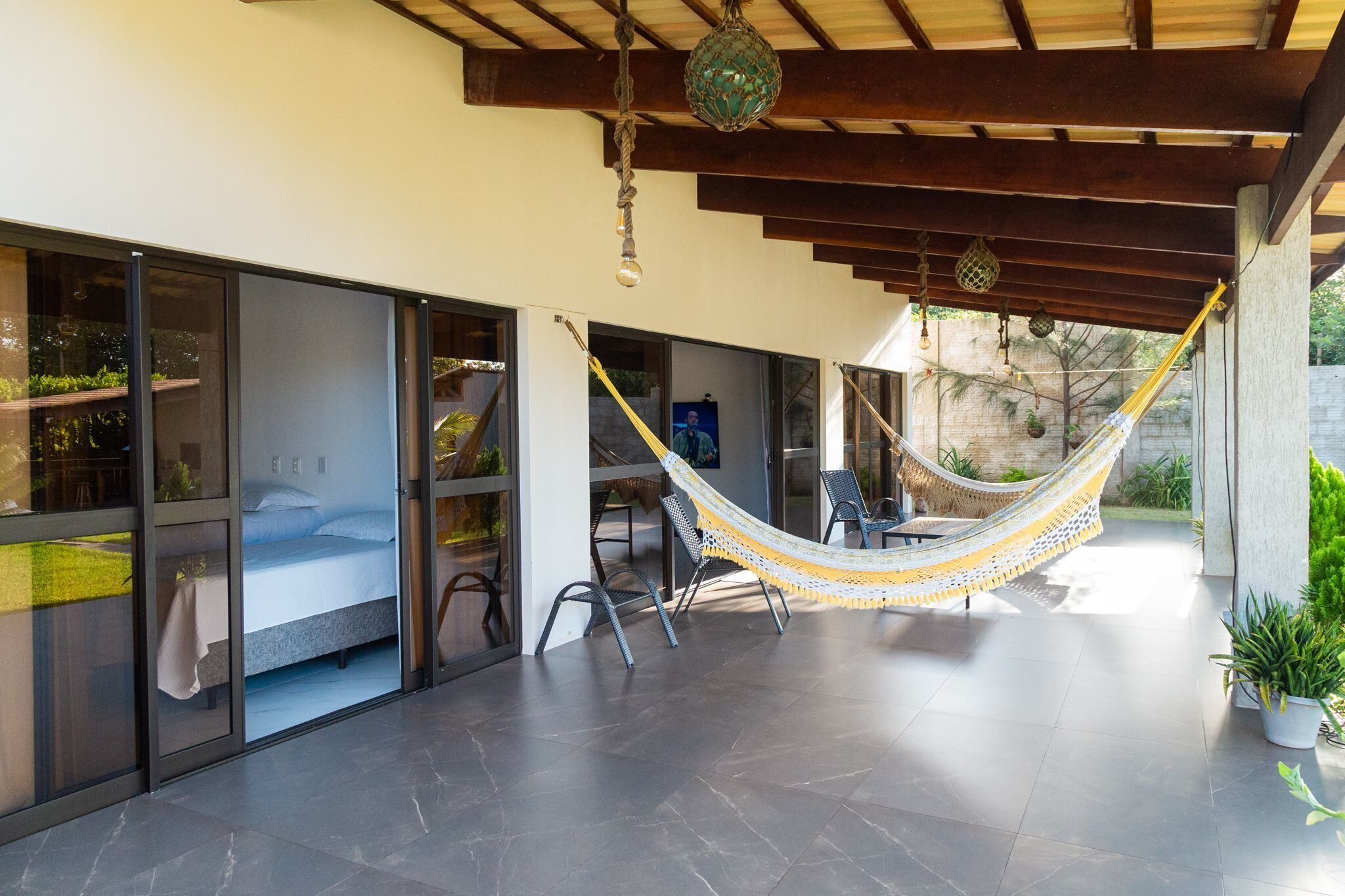 A modern outdoor space with a hammock, a seating area, and a view of the surrounding landscape.