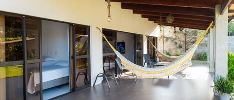 A modern outdoor space with a hammock, a seating area, and a view of the surrounding landscape.