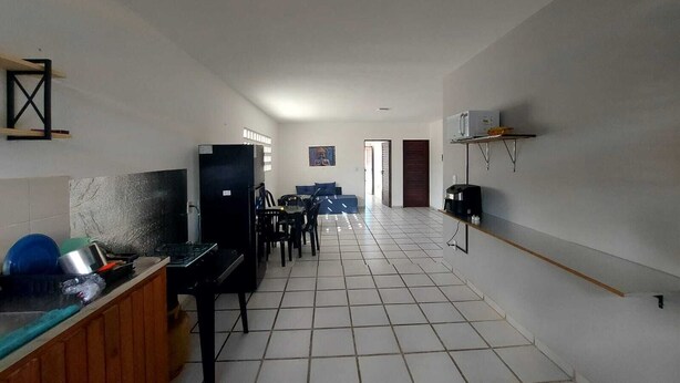Una cocina amplia con comedor, refrigerador, microondas y cafetera.