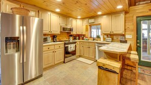 Une cuisine moderne avec des meubles en bois, des appareils électroménagers en acier inoxydable et une porte verte.