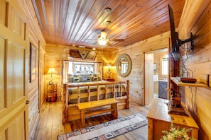 A wooden cabin interior with a bench, a mirror, and a ceiling fan. - Riverfront Helen Cabin  Hot Tub + Fire Pit (Helen)