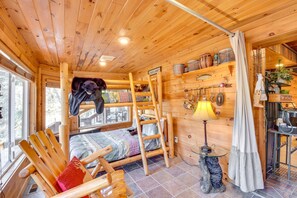 Een gezellig chaletinterieur met een hoogslaper, houten meubels en een rustieke inrichting.